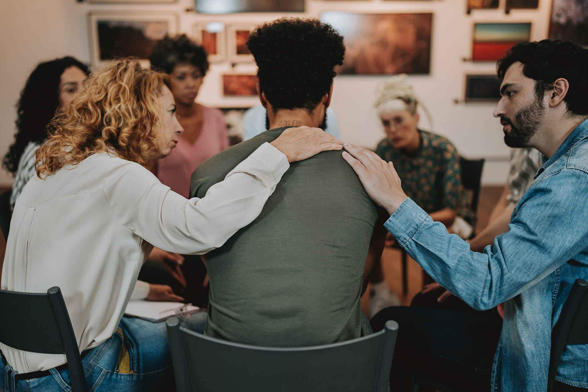 A support group session where Two individuals are comforting a man